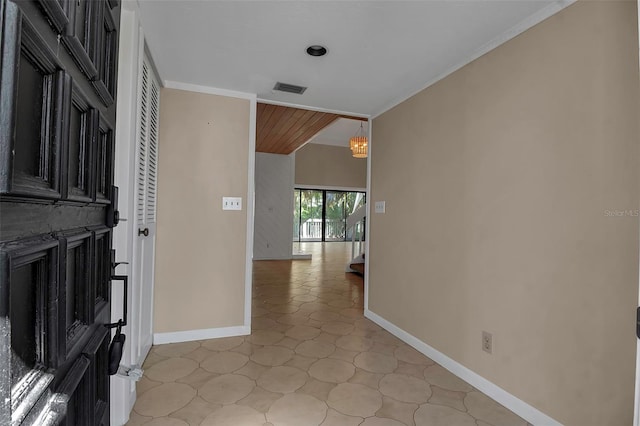 hall featuring a chandelier and crown molding