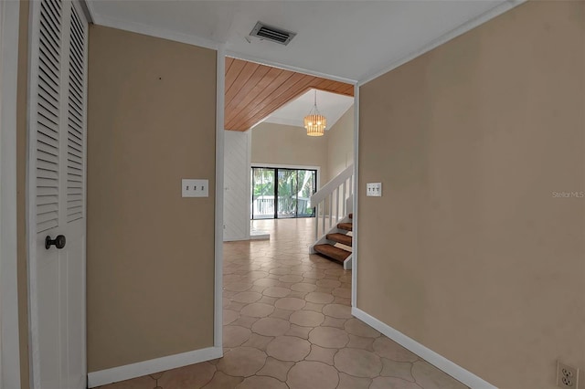 hall with crown molding and a chandelier