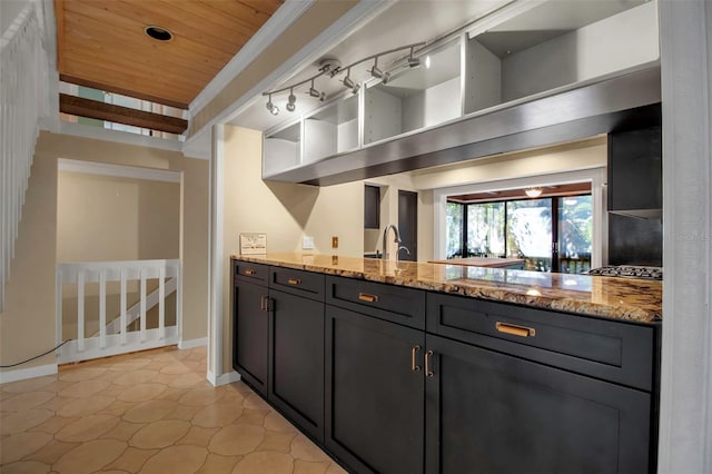 kitchen featuring stainless steel gas stovetop, sink, light tile patterned floors, light stone counters, and wood ceiling