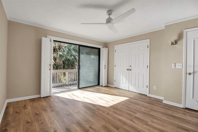 unfurnished room with ceiling fan, ornamental molding, a textured ceiling, and light hardwood / wood-style flooring