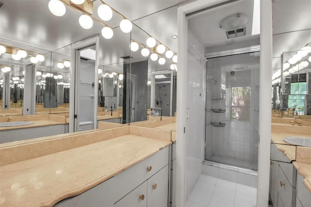 bathroom featuring tile patterned floors, a shower with door, and vanity