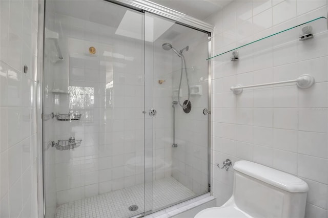 bathroom with toilet, an enclosed shower, and tile walls