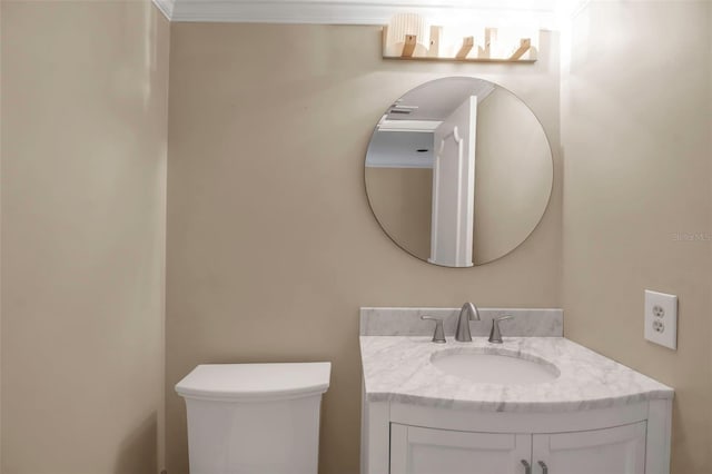 bathroom featuring crown molding, vanity, and toilet