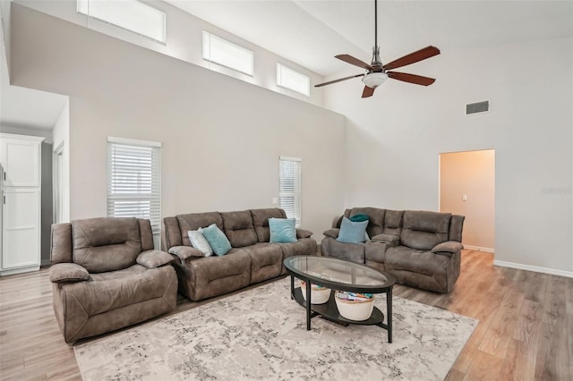 living room featuring hardwood / wood-style floors, ceiling fan, and high vaulted ceiling