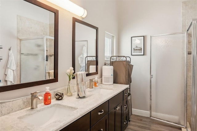 bathroom with wood-type flooring, vanity, and an enclosed shower