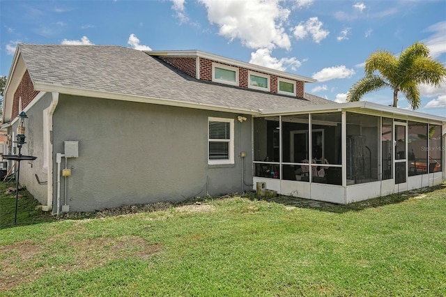 back of property with a sunroom and a lawn