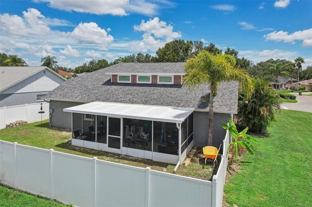 rear view of house with a sunroom and a lawn