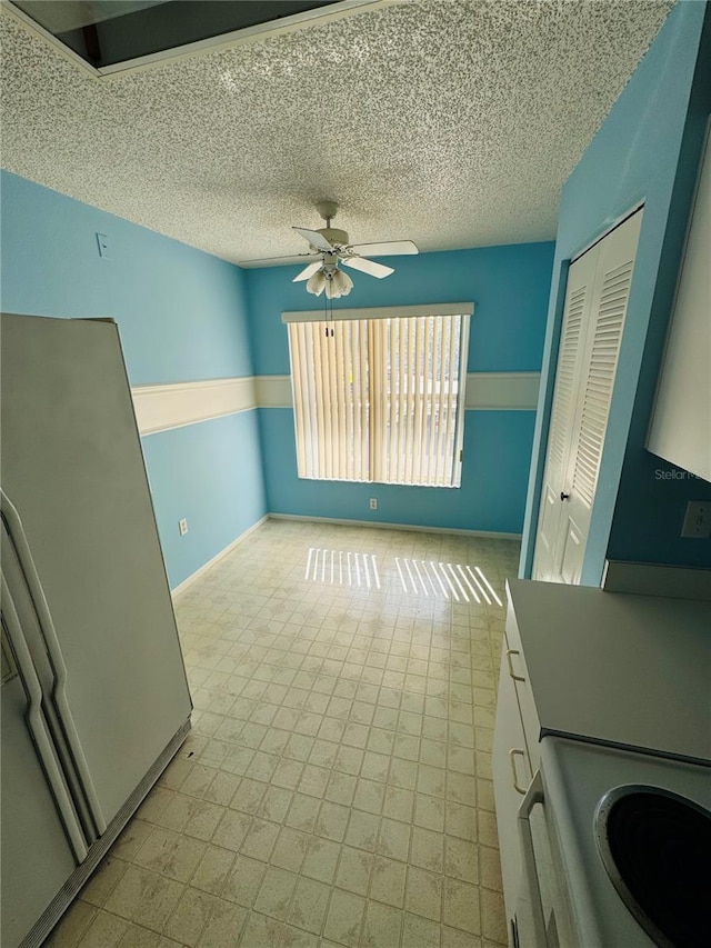 interior space with a textured ceiling and ceiling fan