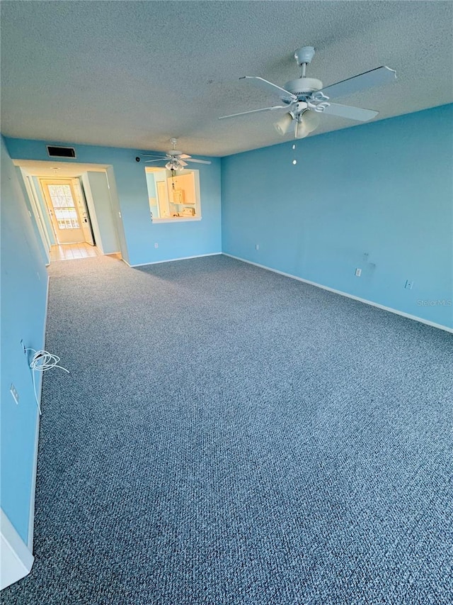 carpeted empty room with a textured ceiling and ceiling fan