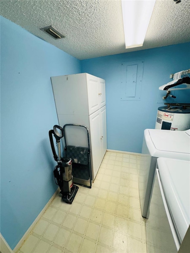 laundry room featuring washer and dryer, cabinets, and a textured ceiling