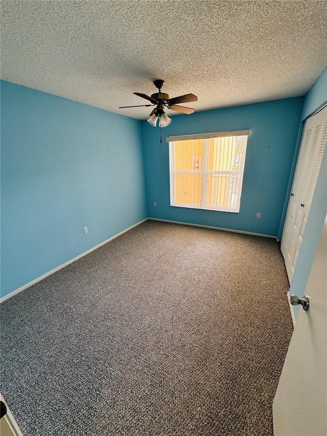 unfurnished bedroom with ceiling fan, a closet, carpet, and a textured ceiling