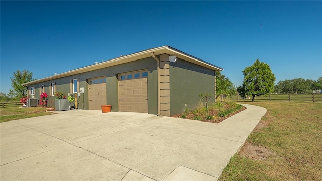 view of outbuilding with central AC unit and a yard