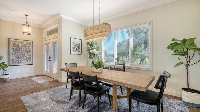 dining room featuring dark hardwood / wood-style flooring, crown molding, and french doors