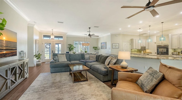 living room featuring dark wood-type flooring, ceiling fan, ornamental molding, and french doors