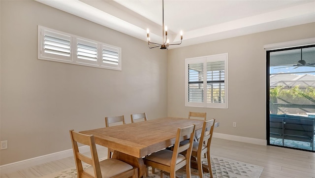 dining area with ceiling fan with notable chandelier and light wood-type flooring