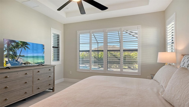 bedroom featuring a raised ceiling and ceiling fan