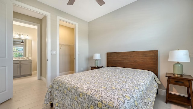 bedroom featuring ensuite bathroom, a closet, a walk in closet, and light hardwood / wood-style flooring