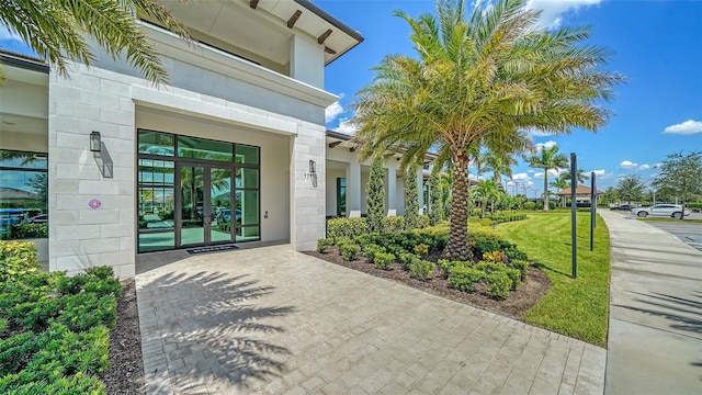 property entrance featuring french doors and a lawn