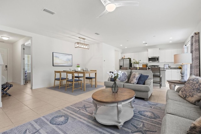 living room with ceiling fan with notable chandelier and light tile patterned flooring