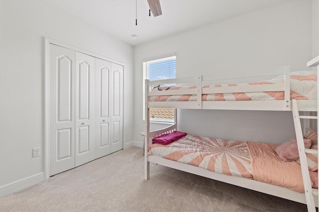 carpeted bedroom with ceiling fan and a closet