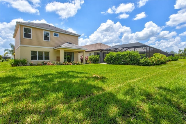 rear view of property with a lawn and glass enclosure