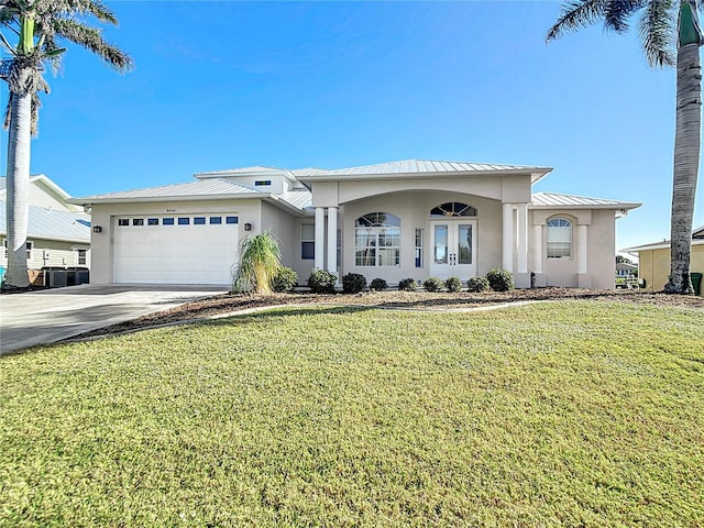 view of front facade with central AC unit, a garage, and a front lawn