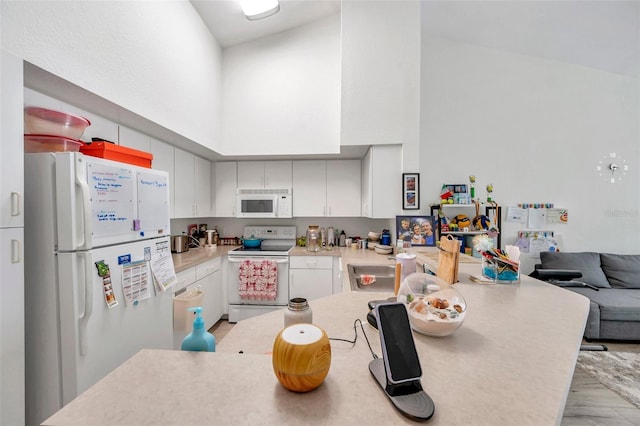 kitchen with white cabinets, light hardwood / wood-style floors, white appliances, and high vaulted ceiling