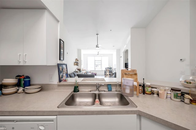 kitchen with white dishwasher, ceiling fan, white cabinets, and sink