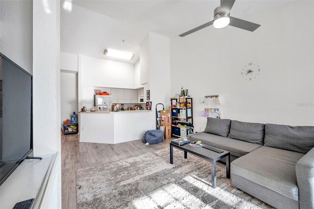 living room with light hardwood / wood-style floors and ceiling fan