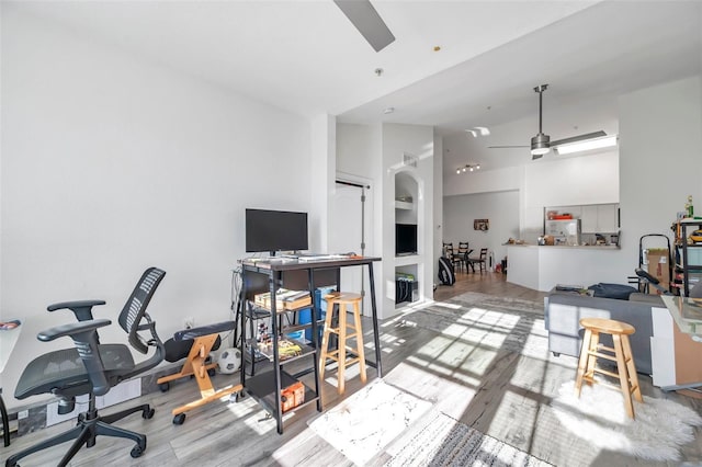 office space with ceiling fan, light hardwood / wood-style flooring, and high vaulted ceiling