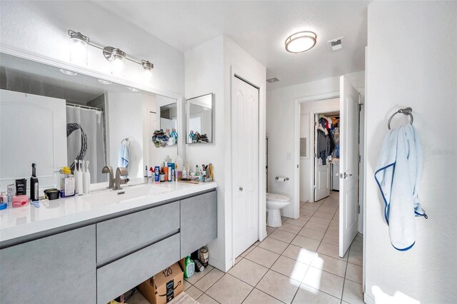 bathroom with tile patterned flooring, vanity, and toilet