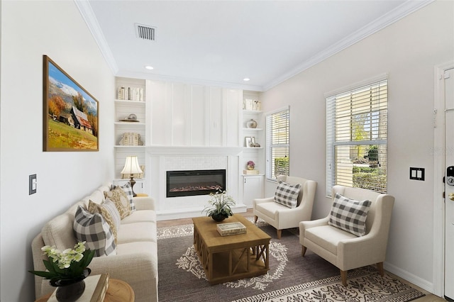 living room featuring built in shelves, crown molding, and hardwood / wood-style floors