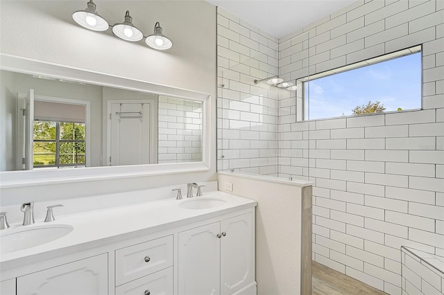 bathroom featuring a tile shower and vanity