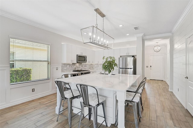 dining room featuring crown molding and light wood-type flooring