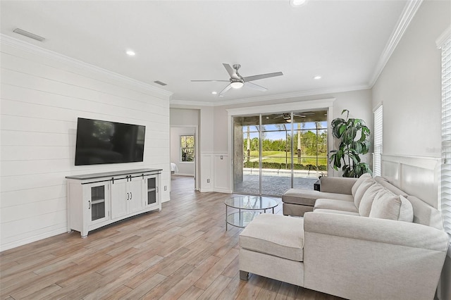 living room featuring ceiling fan, light wood-type flooring, and ornamental molding