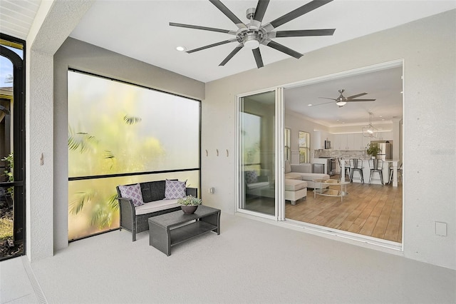 sitting room with ceiling fan and wood-type flooring