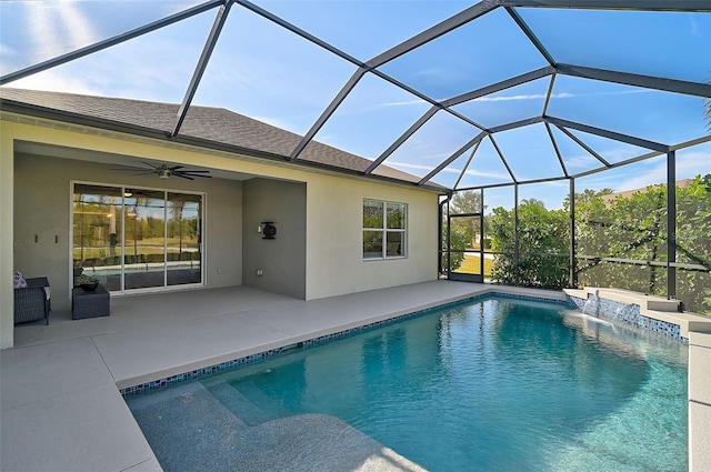 view of swimming pool featuring pool water feature, ceiling fan, a patio, and glass enclosure