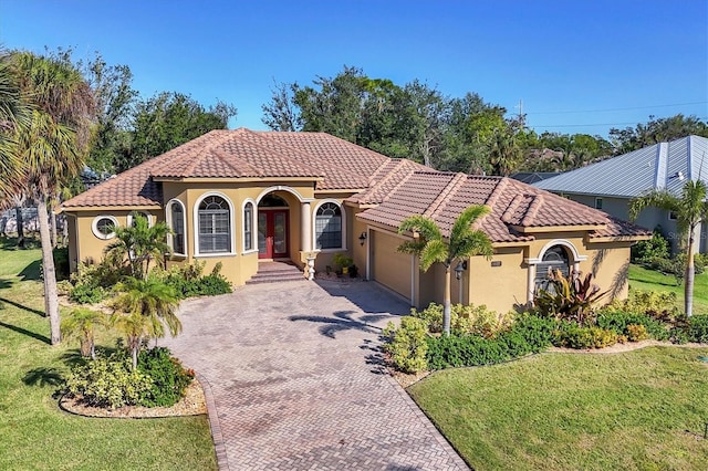 mediterranean / spanish-style house featuring a front yard and a garage