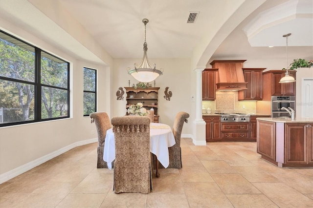 dining space with decorative columns and sink