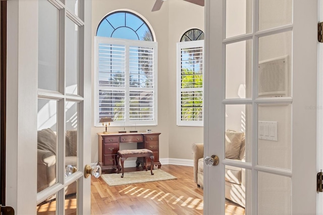 interior space with a wealth of natural light, french doors, ceiling fan, and hardwood / wood-style flooring