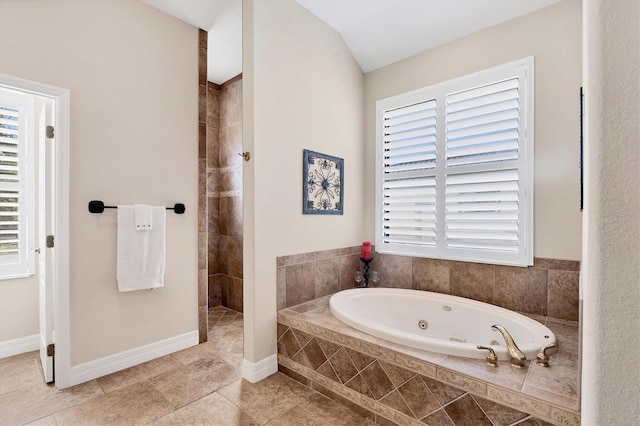 bathroom featuring shower with separate bathtub, vaulted ceiling, and tile patterned floors