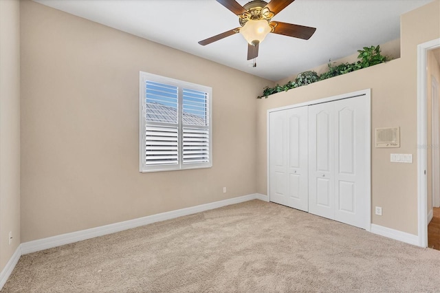 unfurnished bedroom with ceiling fan, light carpet, and a closet