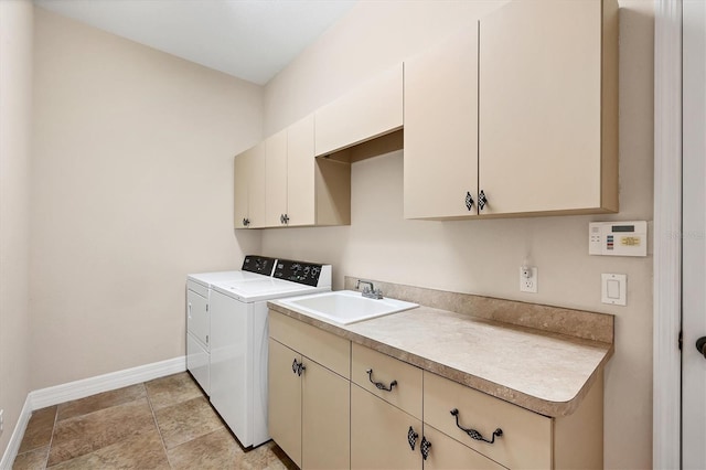 washroom with cabinets, washing machine and dryer, and sink