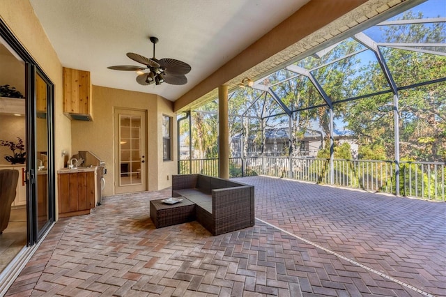 view of patio featuring glass enclosure and ceiling fan