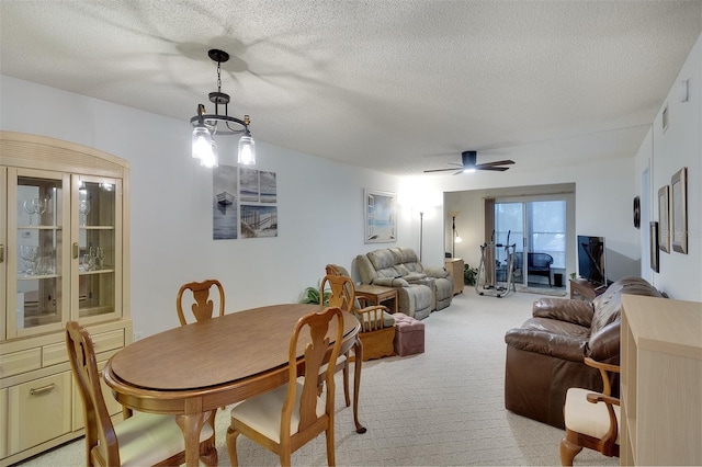 carpeted dining space featuring a textured ceiling and ceiling fan