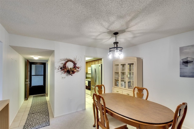 tiled dining room with a textured ceiling