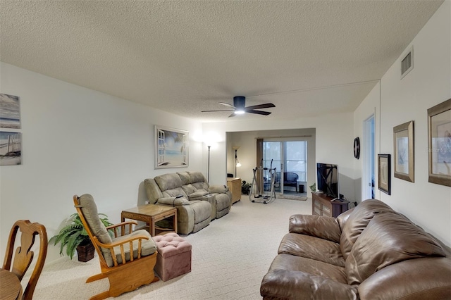 living room featuring a textured ceiling, ceiling fan, and light carpet