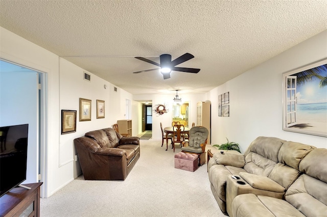 carpeted living room featuring a textured ceiling and ceiling fan