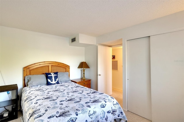 bedroom featuring a closet, light colored carpet, and a textured ceiling