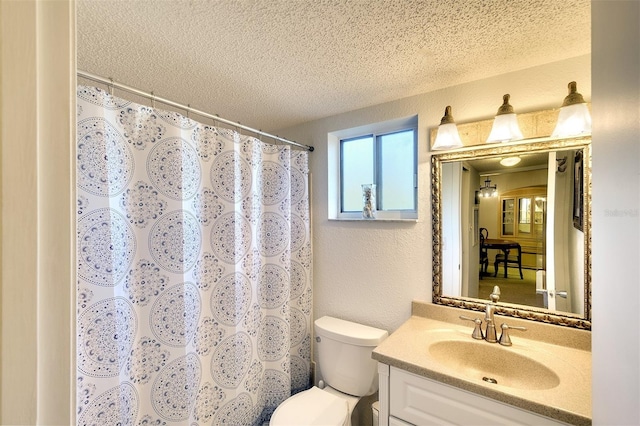 bathroom featuring a shower with curtain, vanity, toilet, and a textured ceiling